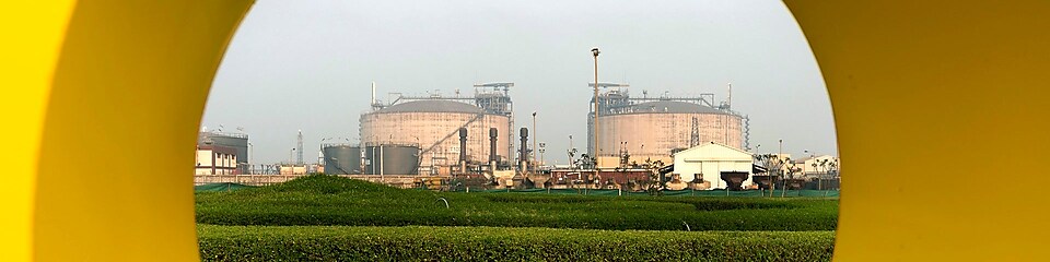 LNG tanks in Hazira, India, surrounded by greenery and fields