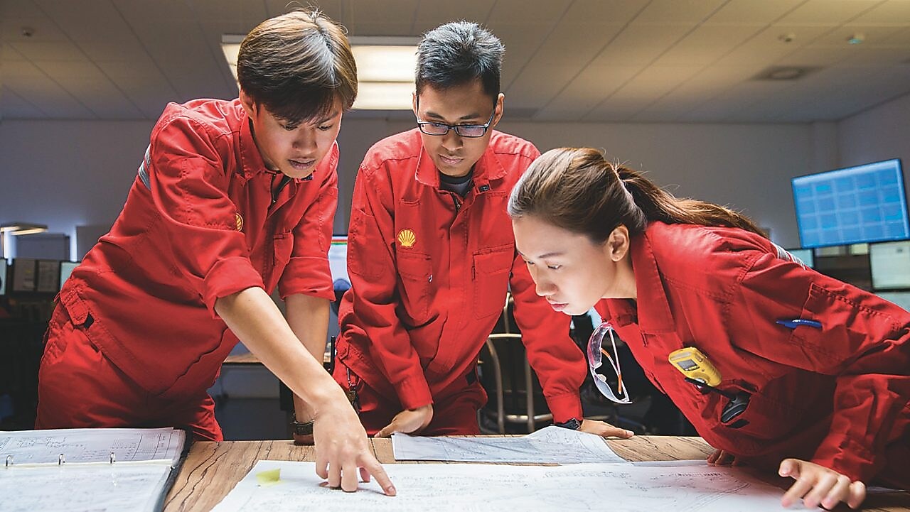 Three employees reviewing plans