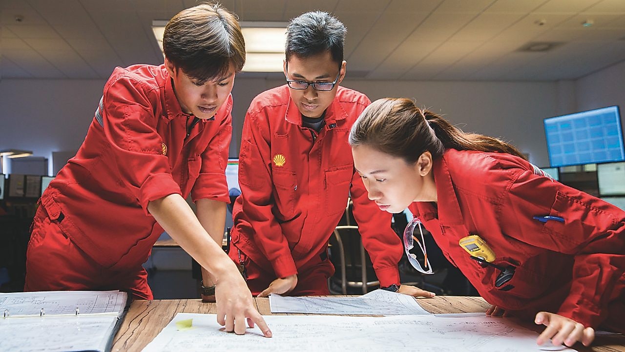 Three employees reviewing plans