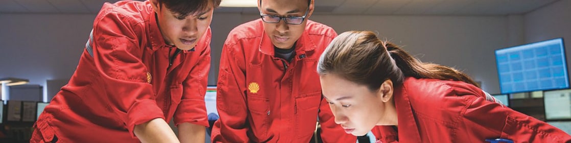 Three employees reviewing plans