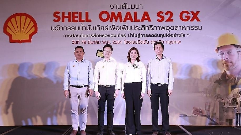 people standing on a stage with a backdrop of shell omala s2 gx