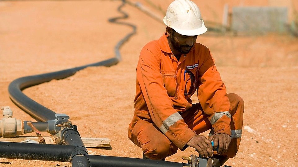 Man in the desert working on small pipeline