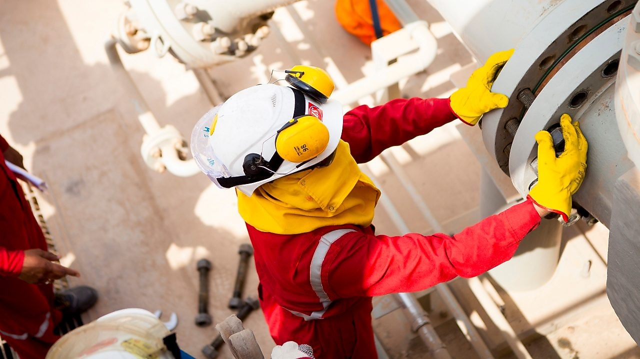 คนงานสวมหน้ากากและถุงมือนิรภัย