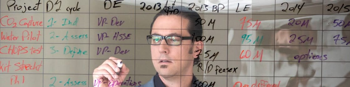 พนักงานกำลังเขียนบนกระดานแบบโปร่งใส