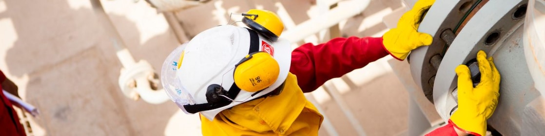 คนงานสวมหน้ากากและถุงมือนิรภัย