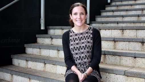 Siobhan Kelly ยืนยิ้มอยู่หน้าบันไดคอนกรีต