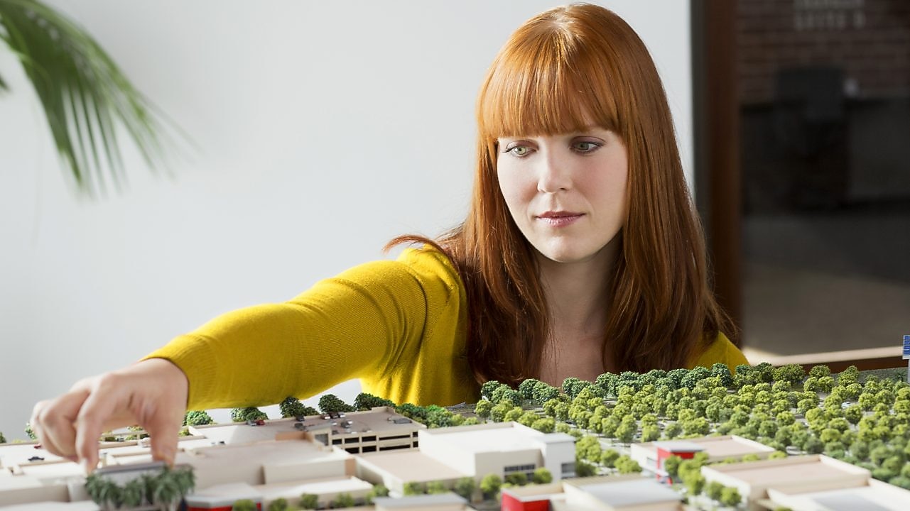 นักธุรกิจหญิงเชื้อสาวคอเคเชียนกำลังตรวจสอบโมเดลขนาด