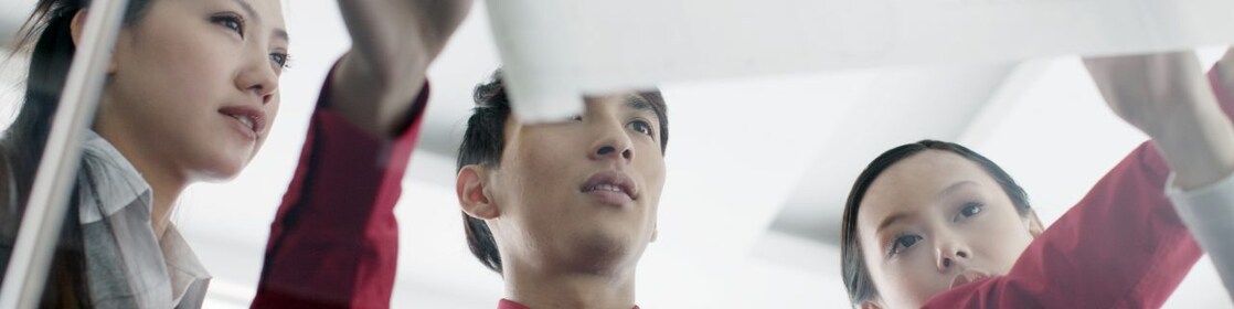 ผู้ชายแสดงพิมพ์เขียวให้เพื่อนร่วมงานดู
