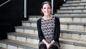 Siobhan Kelly ยืนยิ้มอยู่หน้าบันไดคอนกรีต