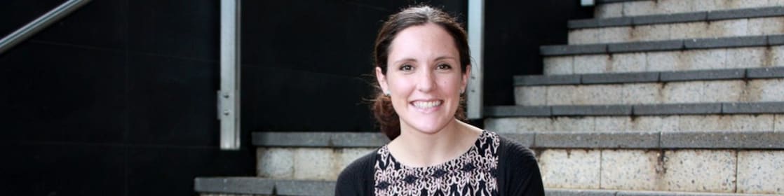 Siobhan Kelly ยืนยิ้มอยู่หน้าบันไดคอนกรีต