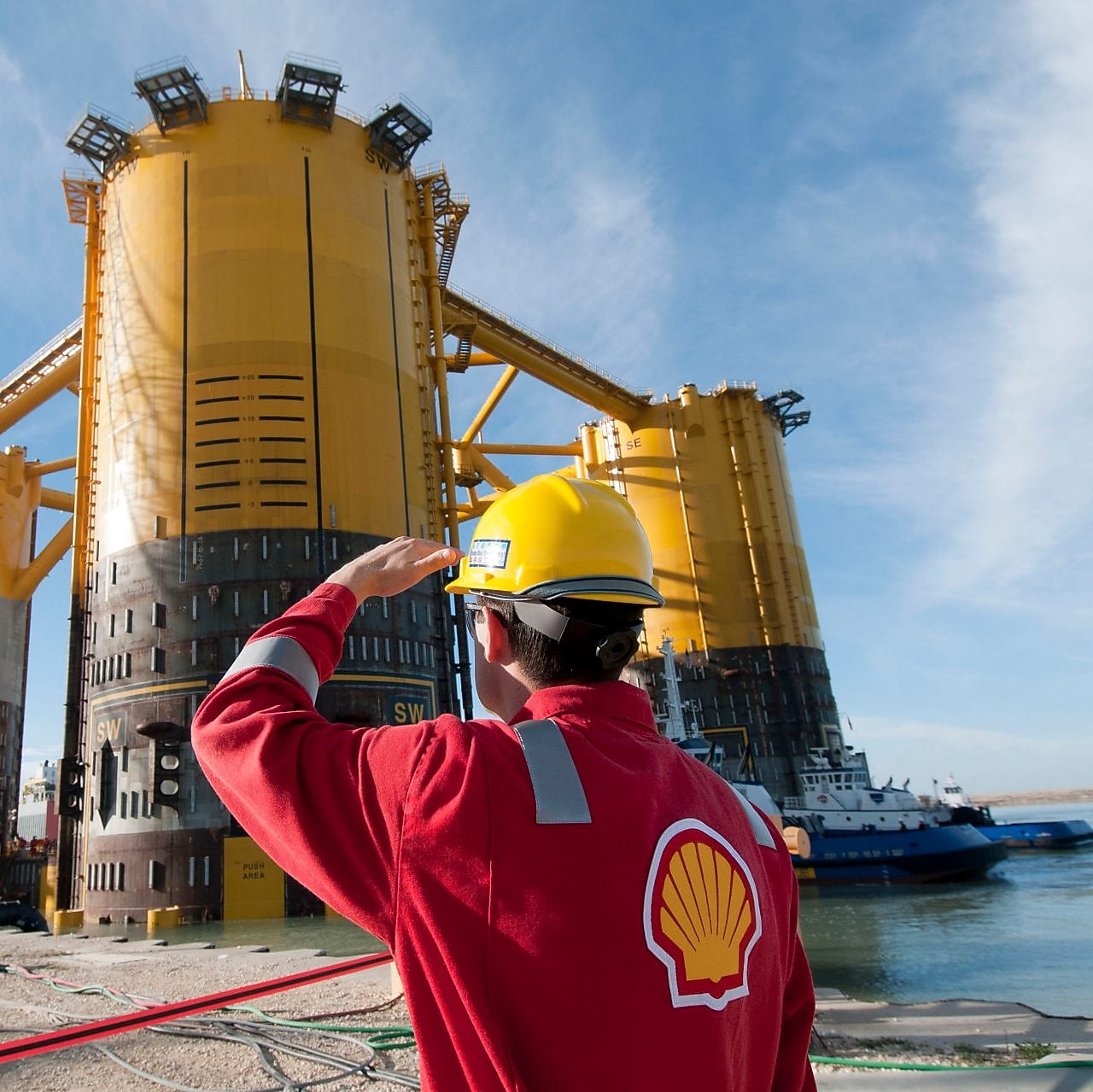 วิศวกรมองขึ้นไปที่แท่นที่กำลังอยู่ระหว่างการก่อสร้าง