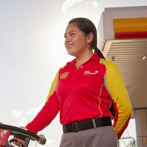 a woman holding an oil dispenser in service station