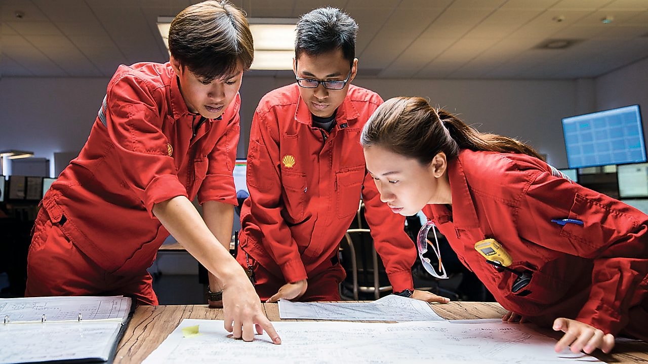 พนักงานสามคนกำลังทบทวนแผนงาน