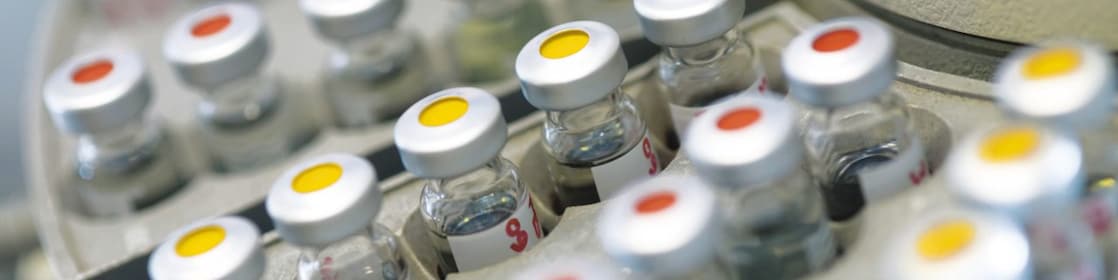 แถวของขวดยาตั้งเรียงรายอยู่ บางขวดมีจุดสีแดงบนฝา บางขวดมีจุดสีเหลืองบนฝา
