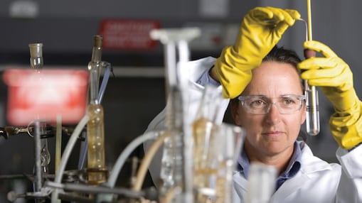 ผู้หญิงสวมแว่นนิรภัยกำลังปฏิบัติงานในห้องทดลอง