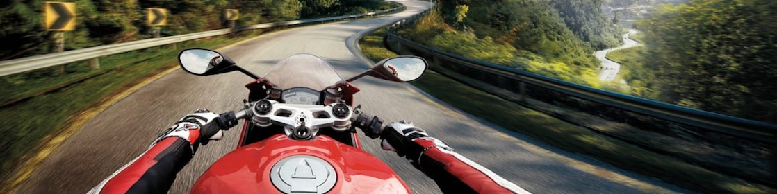 ชายหนุ่มกำลังขับขี่รถมอเตอร์ไซค์ ซึ่งใช้น้ำมันเครื่องเกรดดีเยี่ยมสำหรับมอเตอร์ไซค์