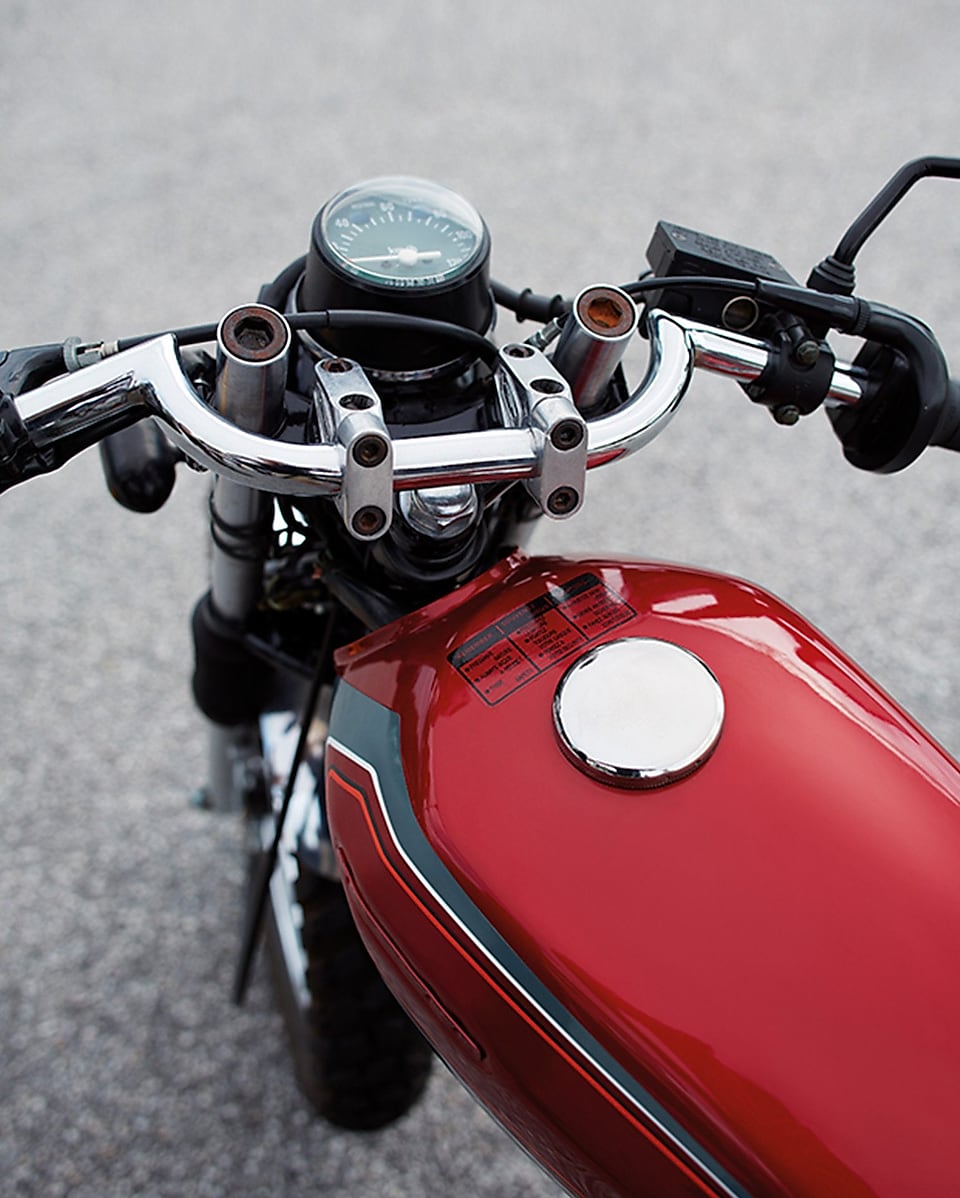 จักรยานยนต์สีแดงที่มีถังน้ำมันเชื้อเพลิงรถ และล้อหน้า, มือจับ และหน้าปัด
